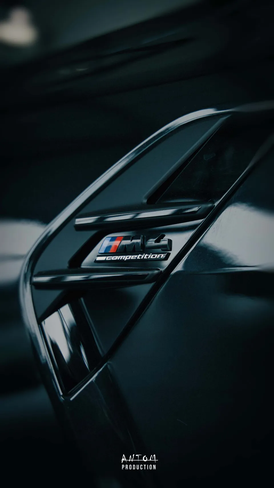 Détail de l'ouïe latérale et du badge d'une BMW M4 Competition en concession