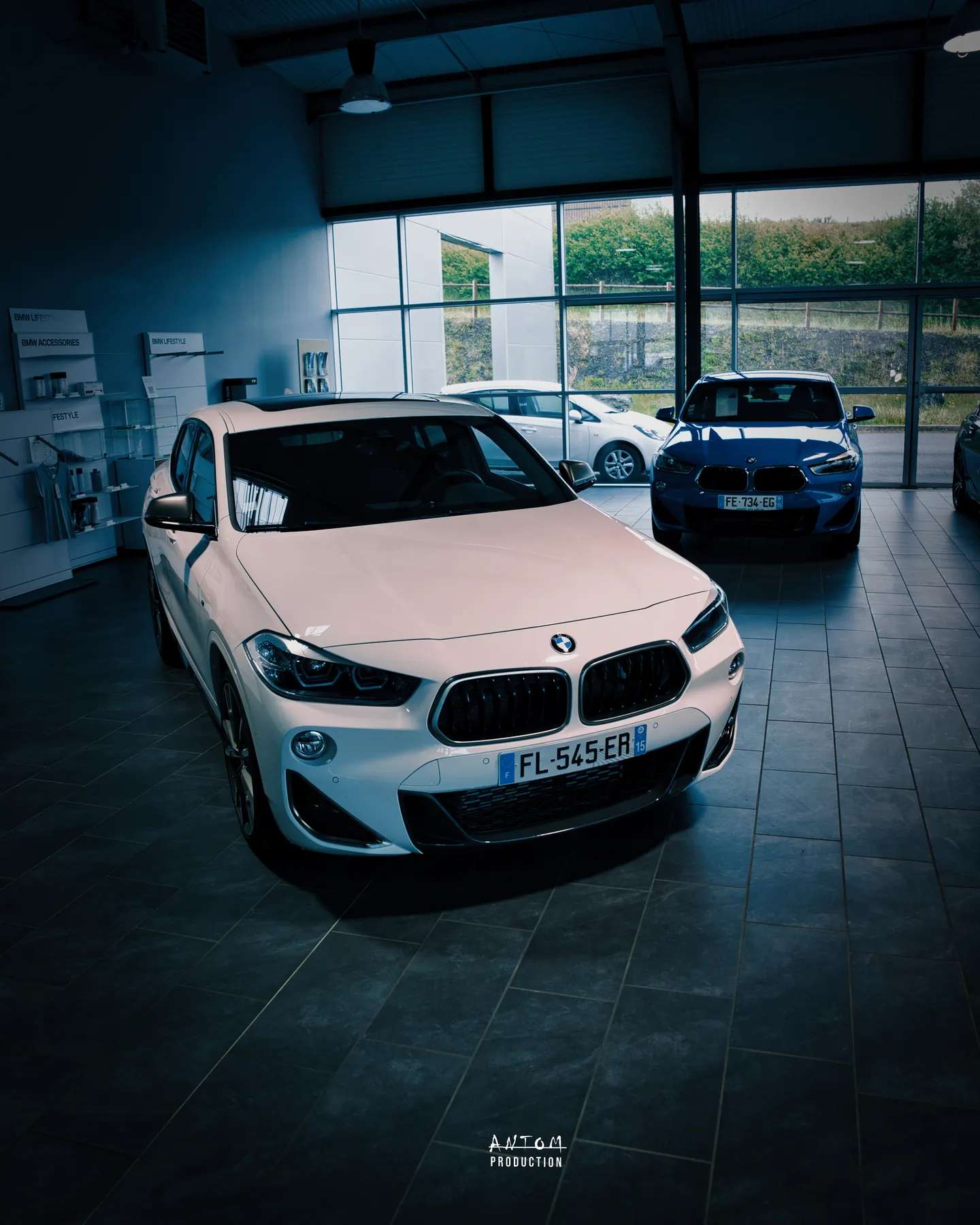BMW X2 blanche et BMW bleue mises en scène dans un showroom