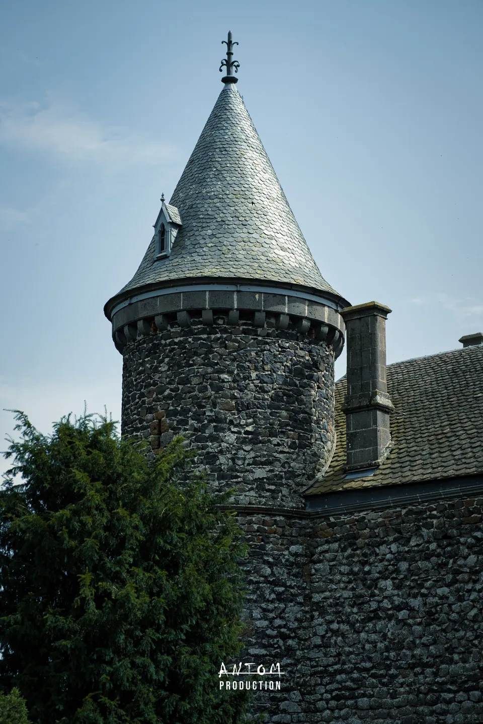 Tour en pierre volcanique coiffée d'ardoise