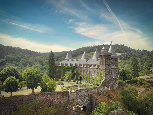 Château aux tours coiffées d'ardoise entouré de son parc, en Auvergne