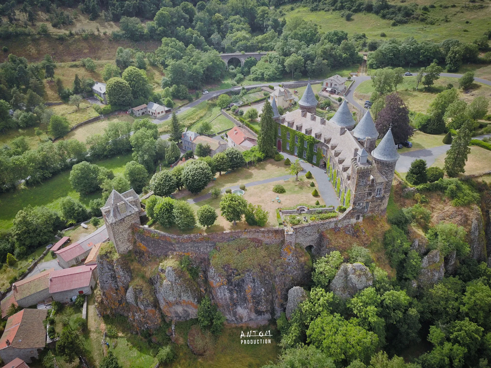 Vue aérienne d'un château auvergnat dominant le village et la vallée