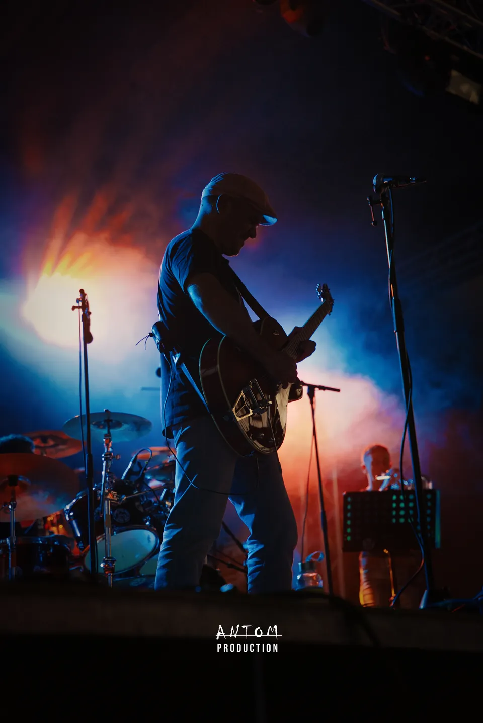 Guitariste sur scène dans une fumée orange et bleue