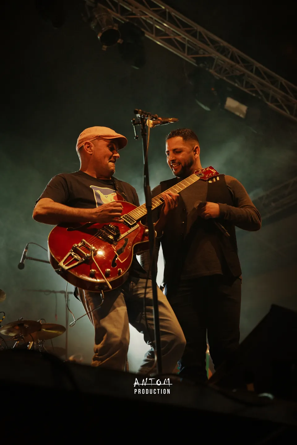 Deux musiciens complices sur scène, guitare rouge