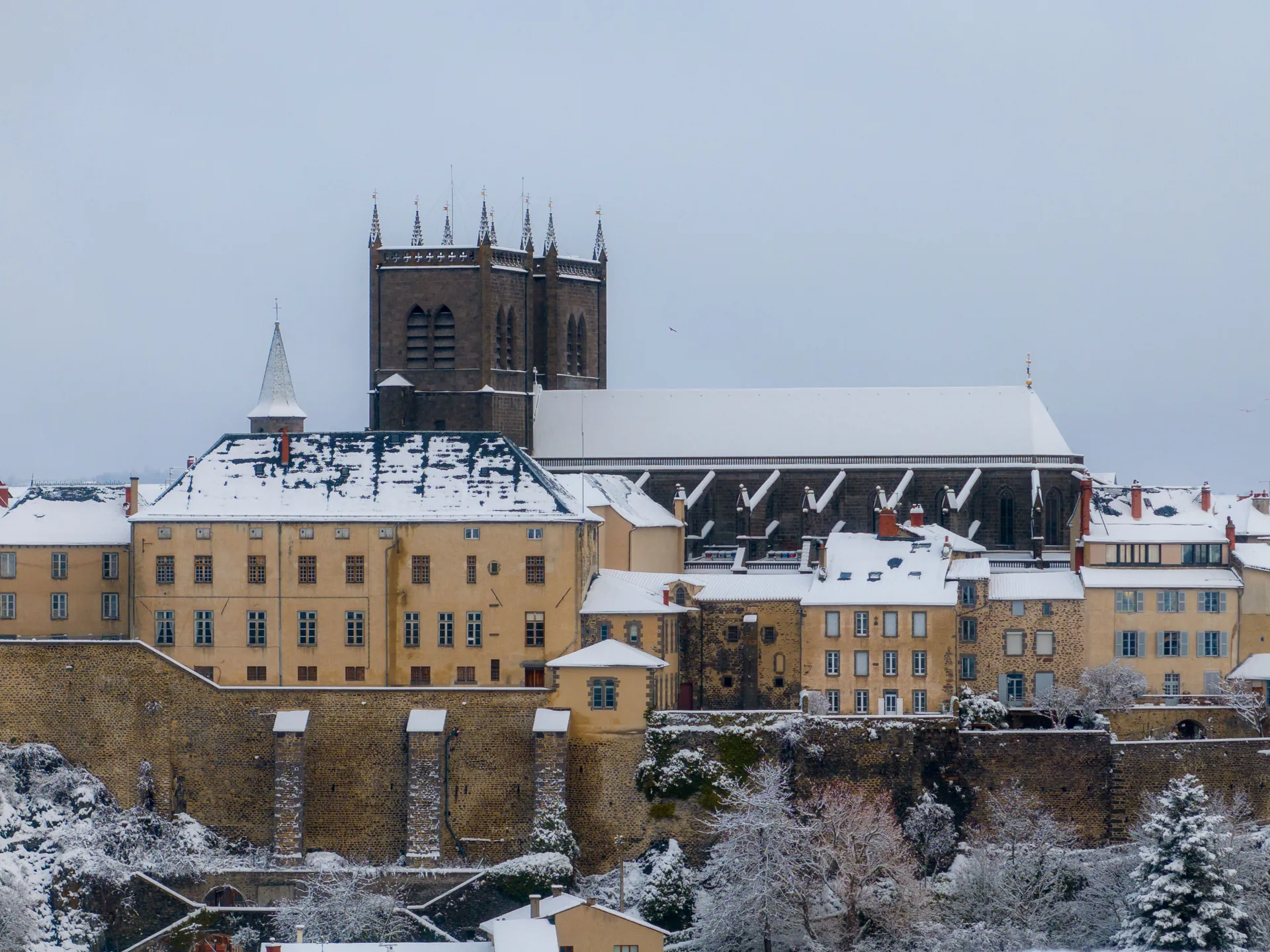 La cathédrale de Saint-Flour et les façades de la ville haute couvertes de neige, vue aérienne