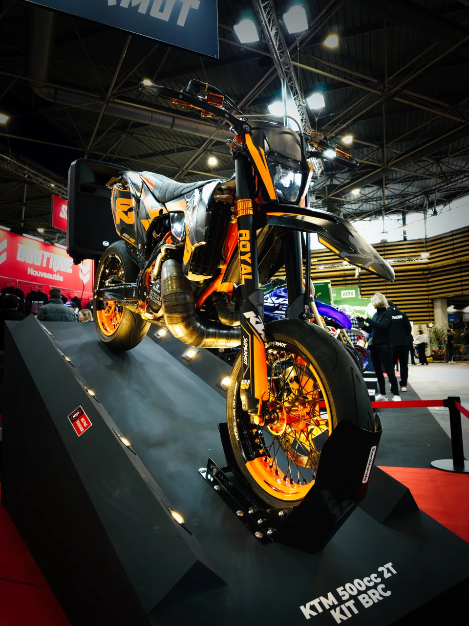 Moto supermotard KTM orange exposée sur un stand du Salon du 2 Roues de Lyon