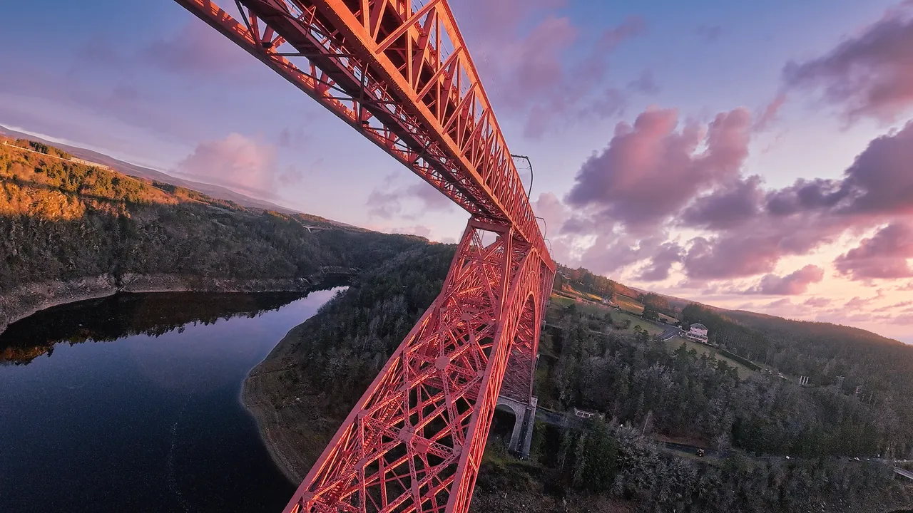 Pile métallique rouge du viaduc de Garabit vue en plongée par drone au-dessus de la Truyère